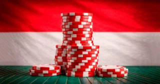 Pile di fiches rosse e bianche con lo sfondo della bandiera di Monaco, simbolo di casinò online.