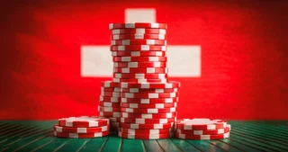 Pile di fiches rosse e bianche con lo sfondo della bandiera della Svizzera, simbolo di un casinò online